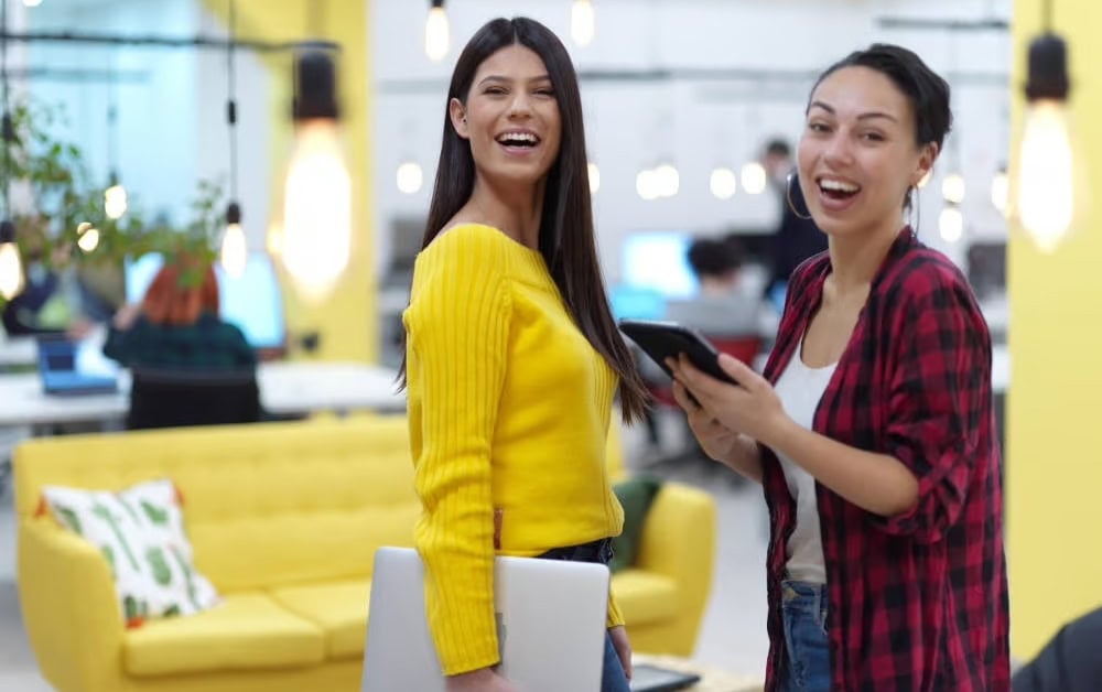 Junge Frauen im Büro: Manche Arbeitgeber bieten ihren Angestellten eine betriebliche Vorsorge in Form einer betrieblichen Krankenversicherung an