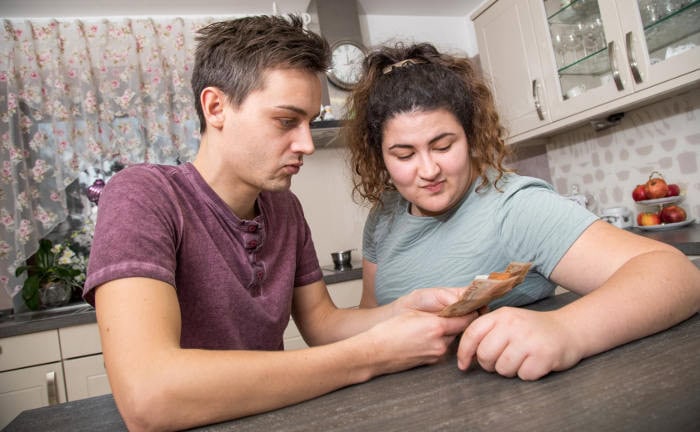 Junges Paar zählt Geld am Küchentisch: Vor allem Sparer mit niedrigem Einkommen investieren ihr Geld kaum.
