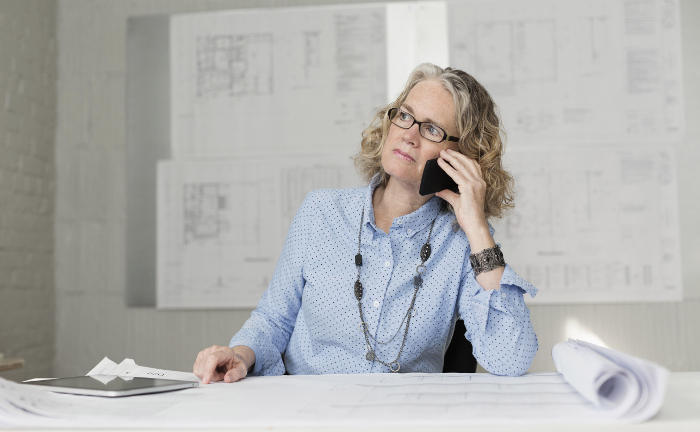 Architektin telefoniert im Büro: Aktuell arbeiten noch einige Personen aus der Generation Babyboomer.