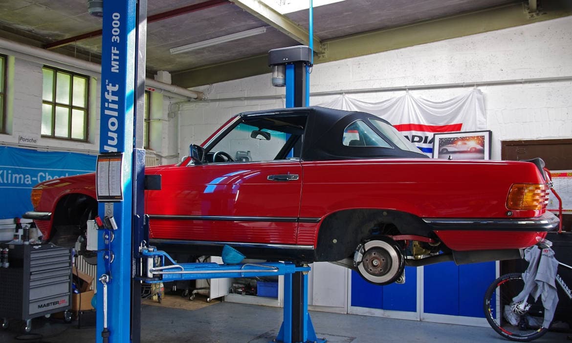 Auto auf der Hebebühne: Auch die KFZ-Versicherung sollte stabil dastehen