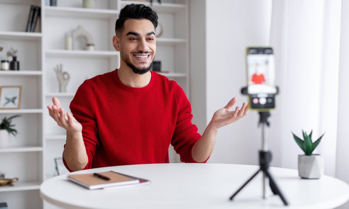 Junger Mann vor der Handykamera: Finfluencer geben Geldtipps über Social Media, eine vernünftige Anlageberatung ersetzt das nicht, betont die Aufsicht Bafin.