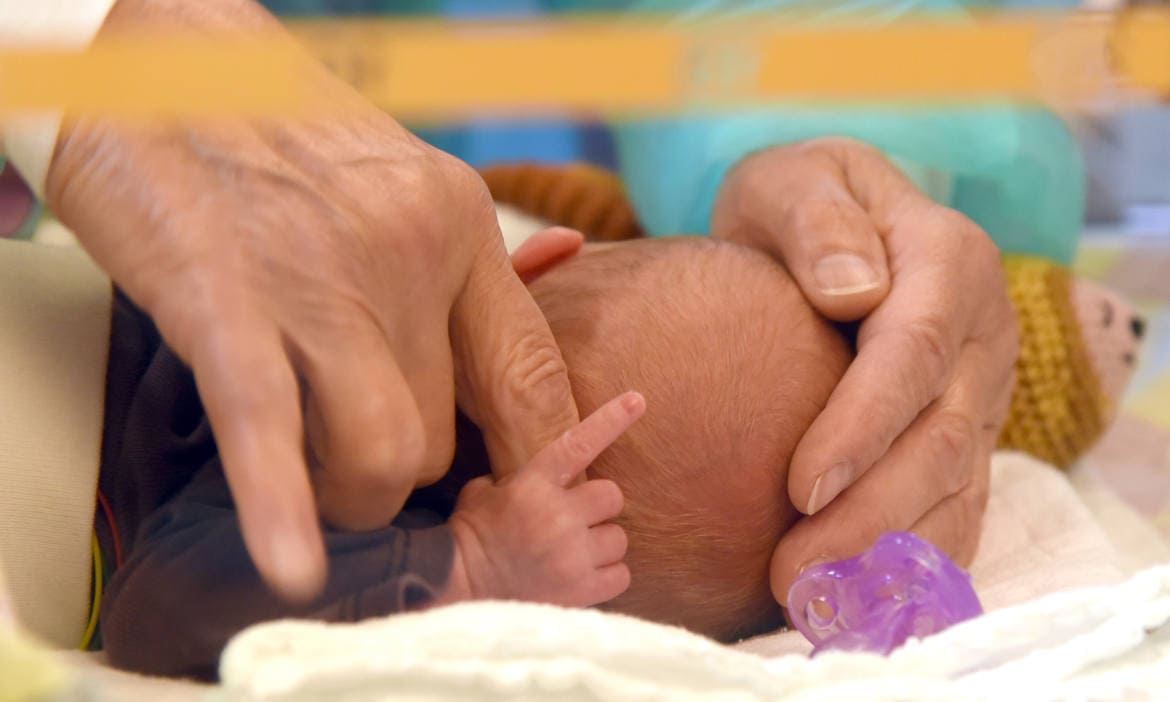 Neugeborenes umklammert Finger der Mutter: Eine gute Risikolebensversicherung bietet Nachversicherungsgarantien bei Geburt oder Adoption eines Kindes