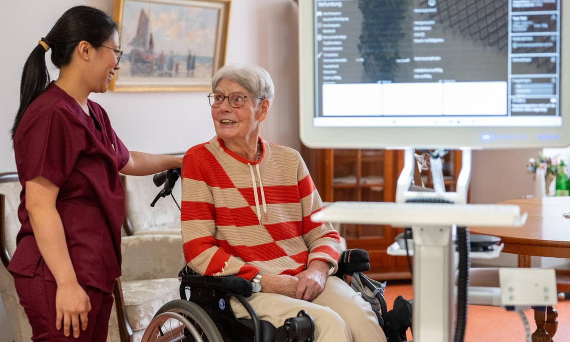 Pflegefachkraft mit Heimbewohnerin: Pflegeversicherung gehört zu den wichtigen Vorsorgen