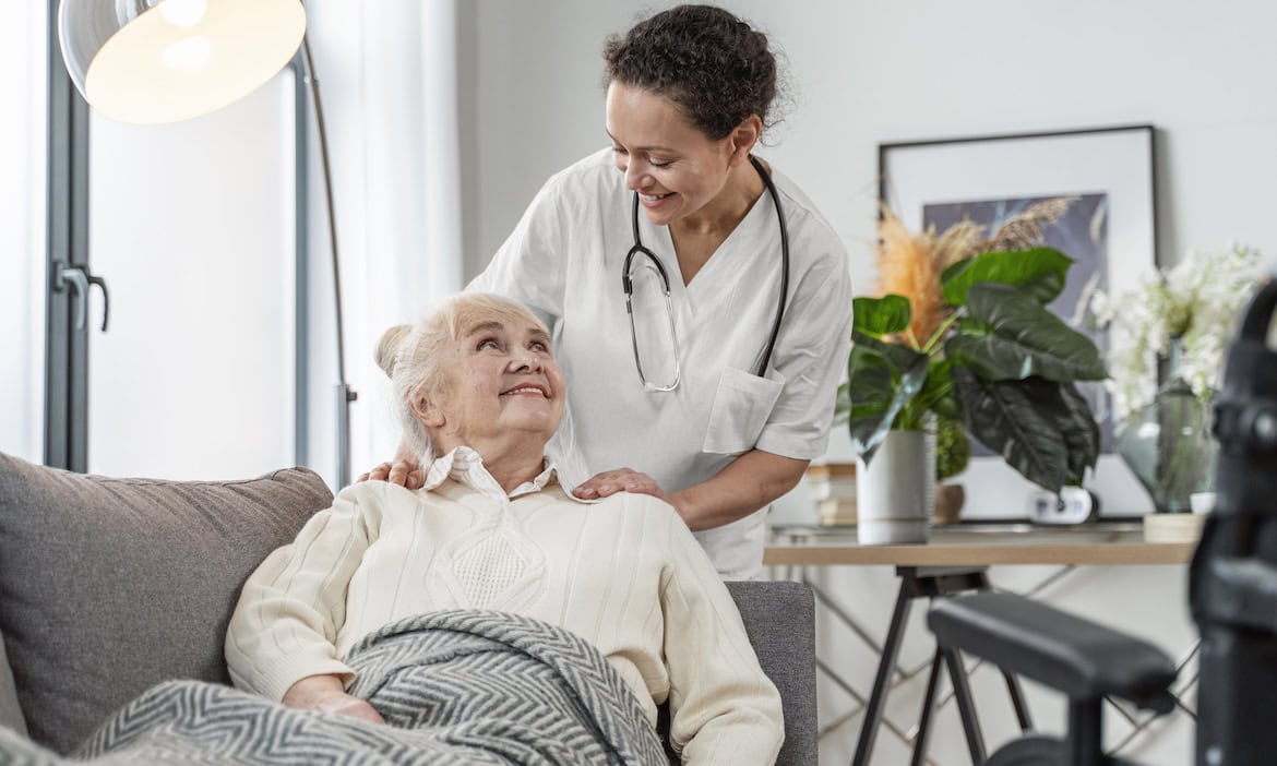 Pflegerin hilft Frau im Rollstuhl: Deutsche Pflegekasse ächzen unter hohen Pflegekosten und vielen Pflegefällen.