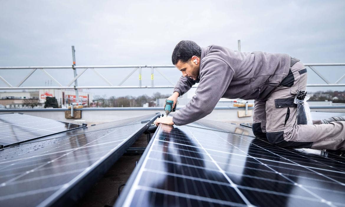 Mitarbeiter des Berliner Installateurs Enpal bring Solarpanele auf dem Dach an: Eine PV-Anlage kann Strom zum Heizen liefern
