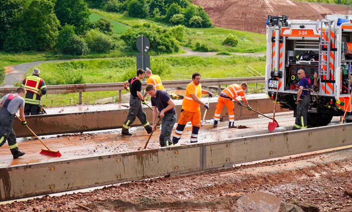 Arbeiter bei Aufräumarbeiten bei einer Autobahn nach Starkregen: Die meisten Schadensfälle durch Wetterextreme gab es 2024 im Saarland.