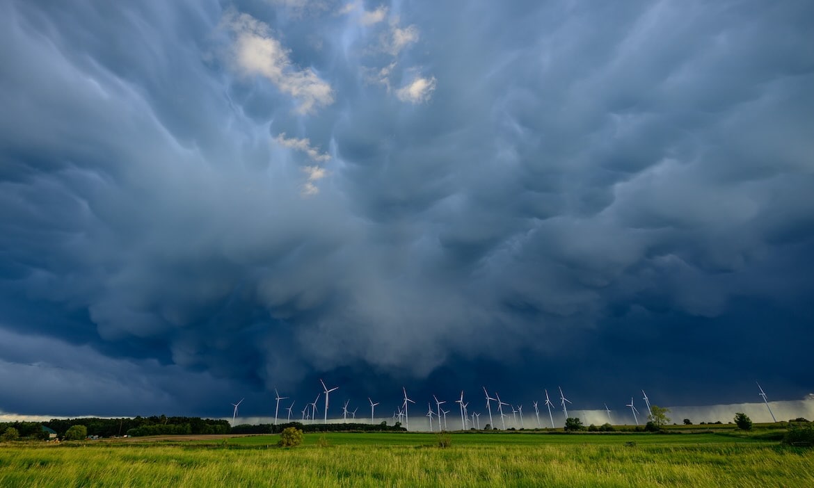 Sogenannte Mammatus Wolken zeigen sich am Rande einer Gewitterzelle über einem Windenergiepark: Extremwetterereignisse nehmen wegen des Klimawandels zu, warnen die Versicherer.