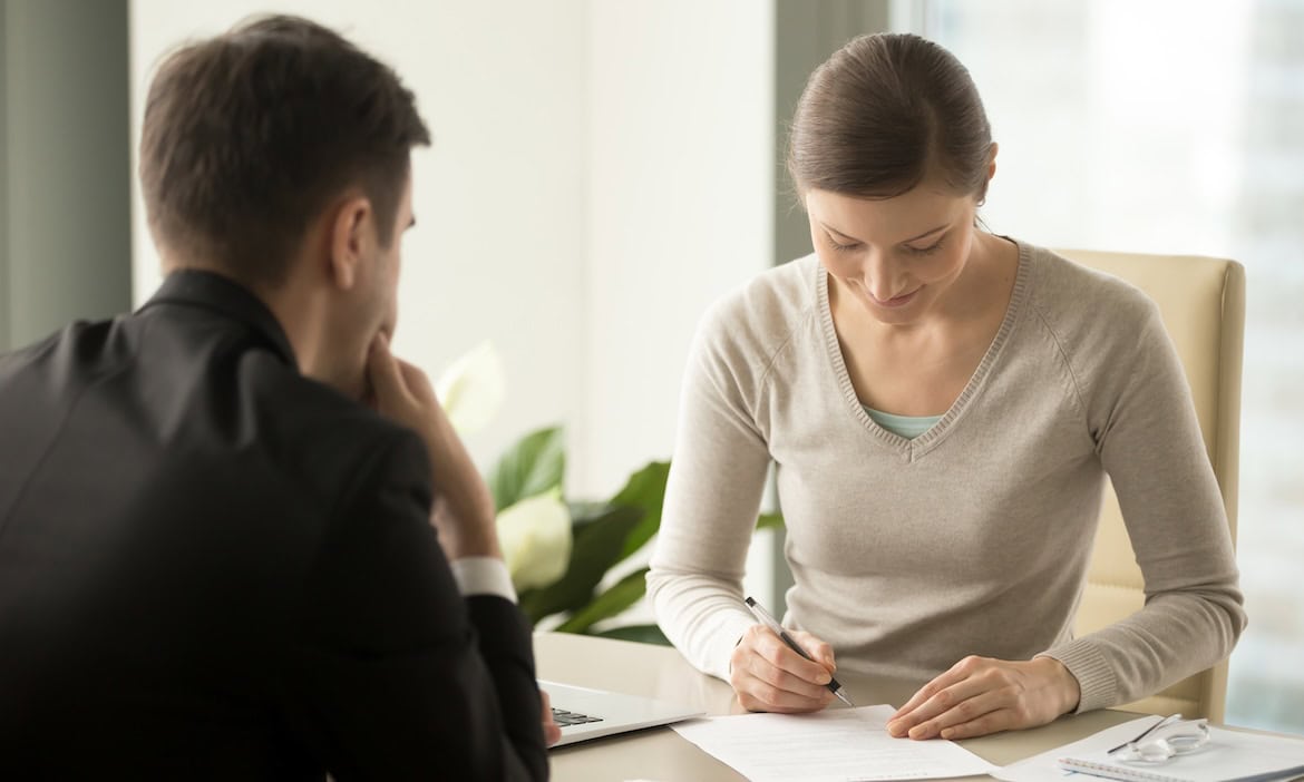 Frau unterzeichnet Scheidungspapiere: Die meisten fühlen sich zu Finanzen bei einer Scheidung nicht gut beraten.