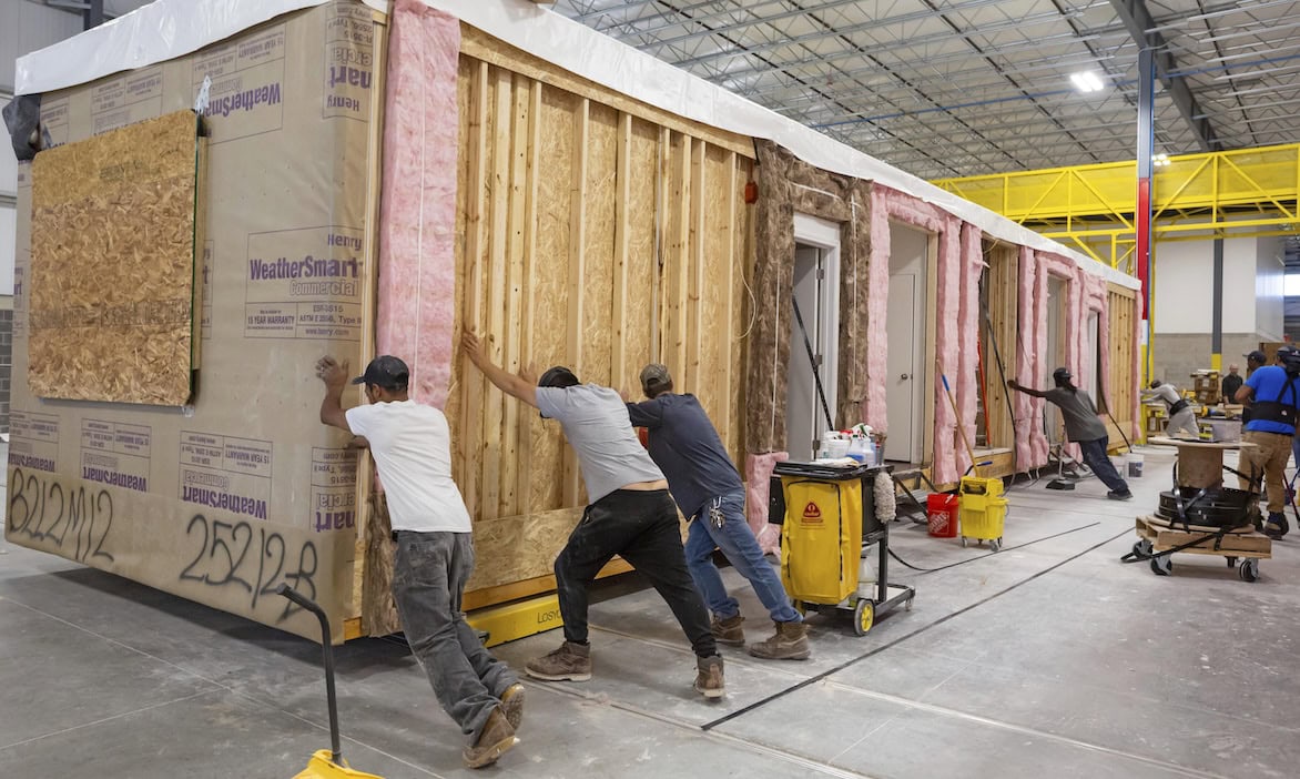 Fabrikarbeiter ziehen ein Fertigbauhaus: Die Analysten von Franke und Bornberg haben in ihrem aktuellen Grundfähigkeit-Rating die Fähigkeit zum Schieben ergänzt. Das Ergebnis: Das Gesamtrating fällt insgesamt schlechter aus.