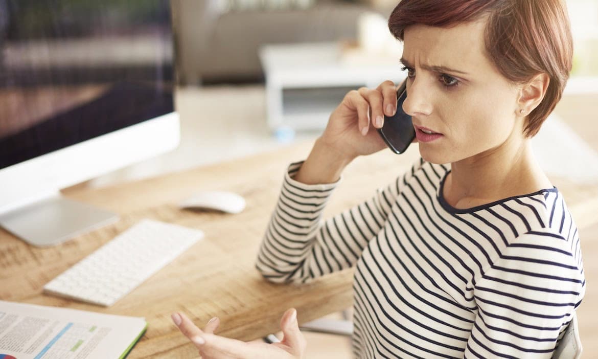 Frau erklärt Kundenservice ein Problem: Chatbots sind zwar weitverbreitet, aber nicht alle Kunden sind von der KI-Beratung von Versicherern überzeugt.