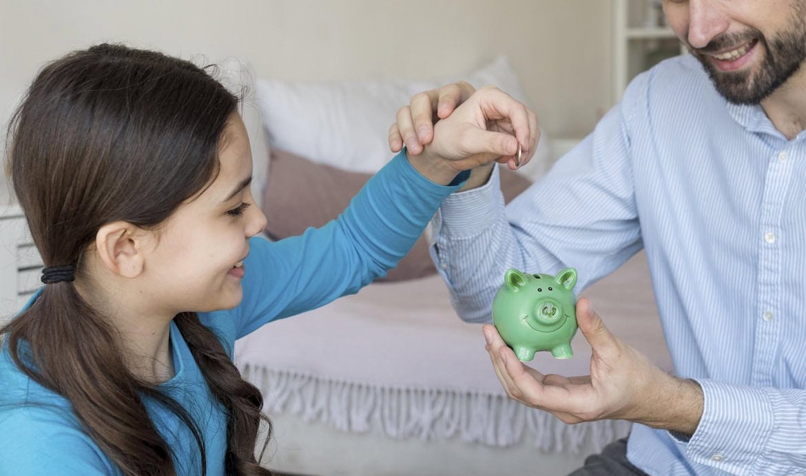 Mädchen steckt Geld in Sparschwein: Der GDV stellt einen kostenfreien Frühstart-Rechner bereit, damit Interessierte ihre Frühstartrente berechnen können.