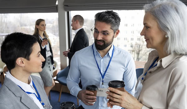 Menschen unterhalten sich auf einer Messe Foto: Freepik