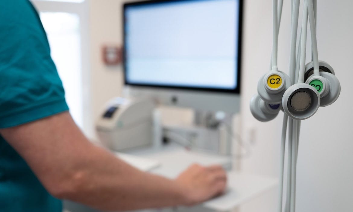 Ein Hausarzt arbeitet in seiner Praxis am Computer: Der GKV-Spitzenverband kritisiert, wie die Bundesregierung die Finanzierungslücken in der Kranken- und Pflegeversicherung schließen möchte.