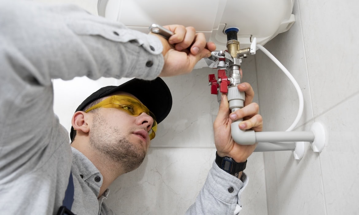 Mann repariert Wasserleitung: Leitungswasserschäden bleiben laut Experten oft lange unentdeckt.