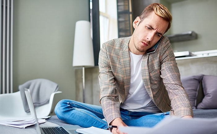 Mann schaut auf seine Finanzdokumente – die Wahl zwischen ETFs und aktiv gemanagten Fonds kann schwerfallen.