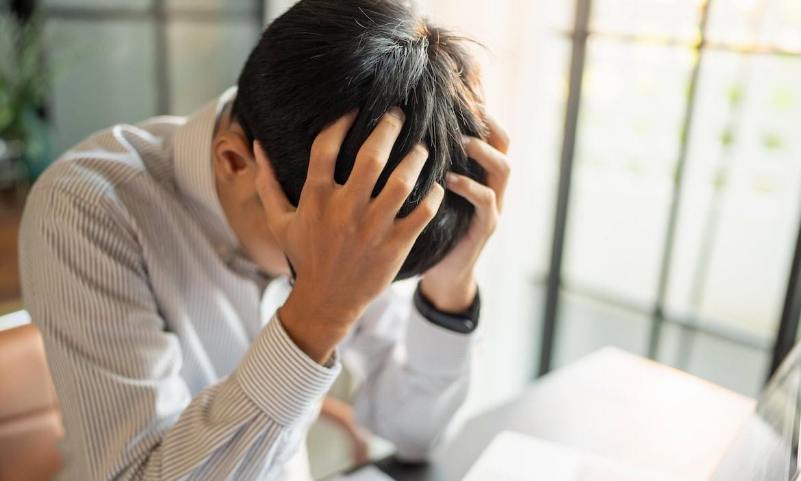 Gestresster Versicherungsmakler im Büro: In einer aktuellen Studie beklagen sich viele Versicherungsmakler über den regulatorischen Aufwand.