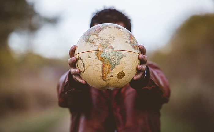 Person mit Globus – der MSCI World ETF scheint wie das ideale Investment.