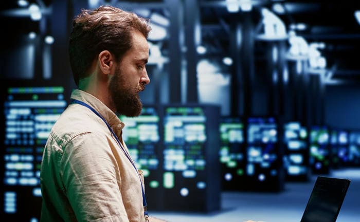 Ein Mitarbeiter arbeitet in einem Serverraum: Wegen der steigenden Cyberbedrohungen benötigen Firmen für den Ernstfall eine Cyberversicherung.